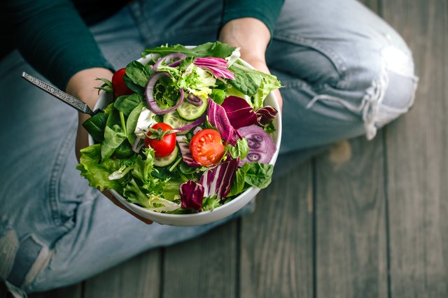 Fresh salad in hands view from above