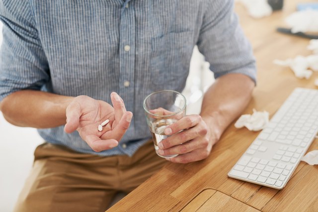 man holding water and magnesium citrate pill in his hands