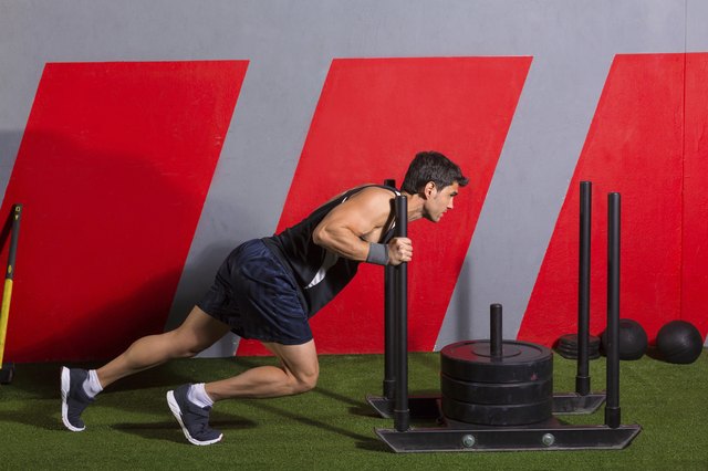 sled push man pushing weights workout exercise