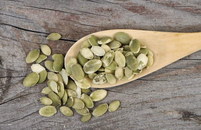 Pumpkin seeds in a wooden spoon.
