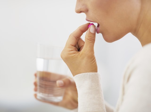 closeup on young woman eating pill