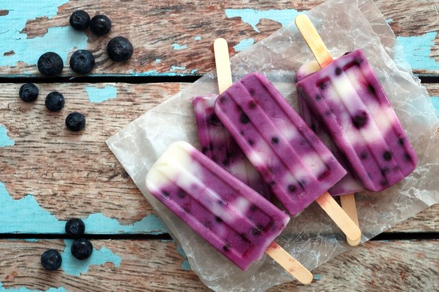 Homemade blueberry vanilla ice pops in a cluster on paper