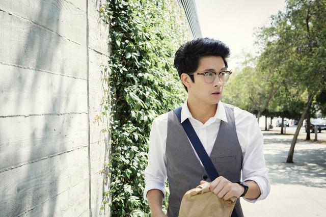 Young man walking down street carrying takeaway