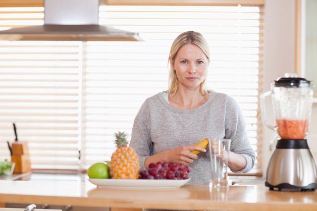Woman preparing fruits for the blender