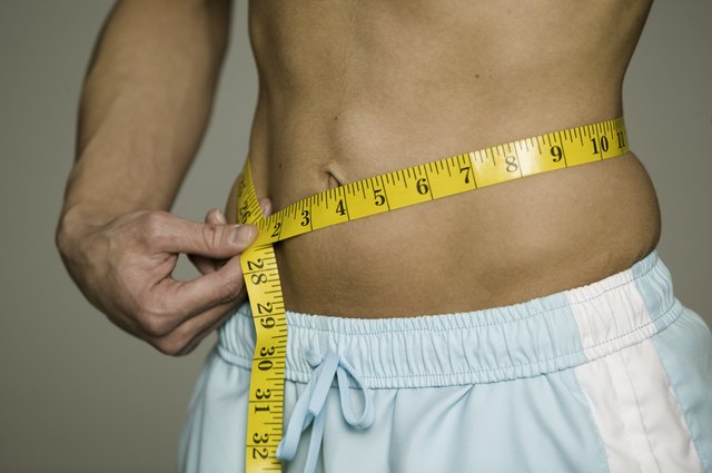 Man measuring waist , mid section