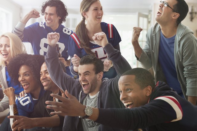 Friends cheering at game on television