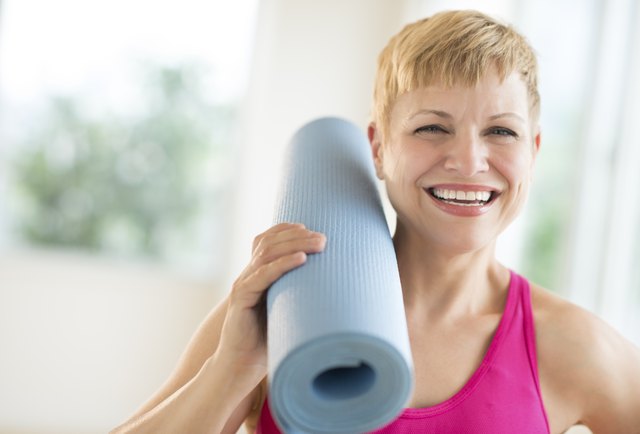 Cheerful Woman Holding Rolled Up Exercise Mat