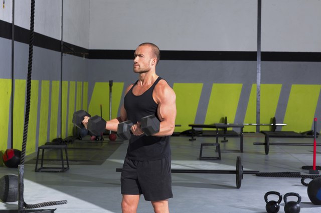 Gym man with dumbbells exercise crossfit