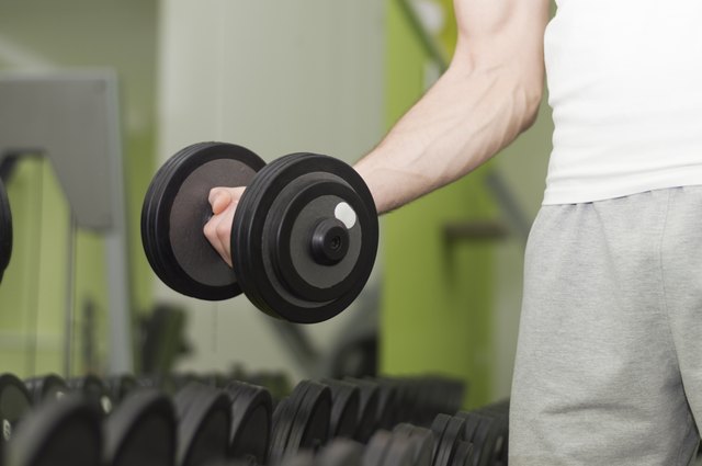 Unrecognizable person taking dumbbells in a gym