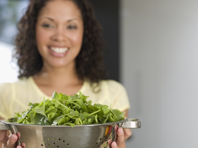 Mixed Race woman holding colander of salad