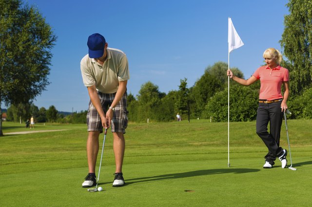 Young sportive couple playing golf on a course