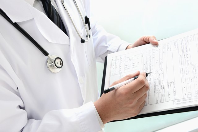 Doctor writing on medical record