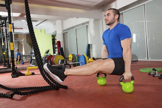 Crossfit fitness man L-sits Kettlebells L sits exercise