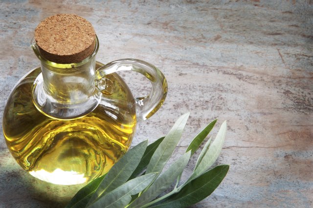 Olive Oil and Leaves on Rustic Timber