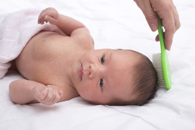 Newborn baby with mother combing