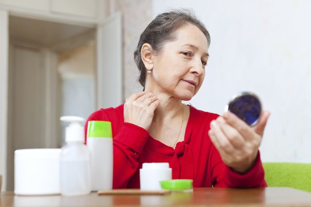 Mature woman stares on her neck