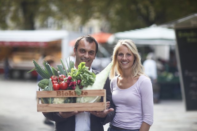 Couple walking with box of vegetables from market