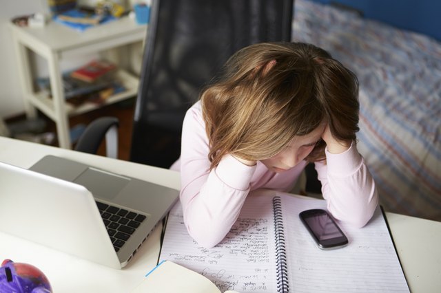 Girl Using Mobile Phone Instead Of Studying In Bedroom