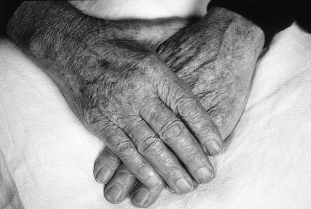 Hands of an elderly person one on top of the other (black and white)