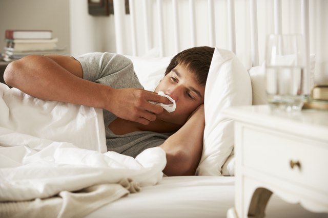 Sick Teenage Boy In Bed At Home