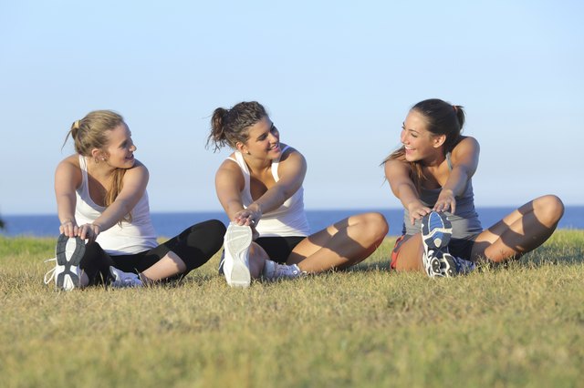 Group of three women stretching after sport