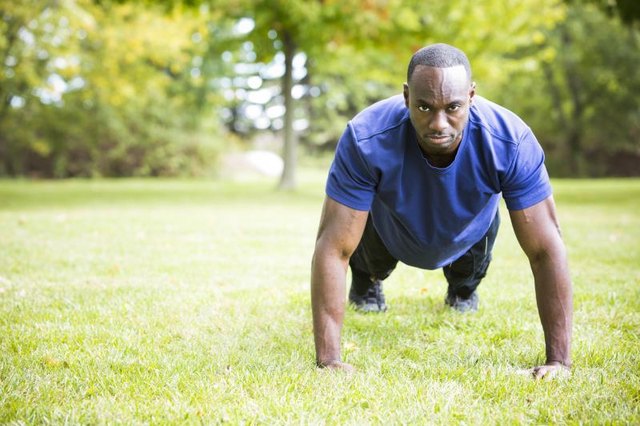 young black man wearing athletic wear doing exercise in the fall park