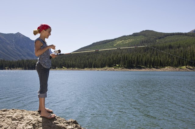 Girl fishing by lake