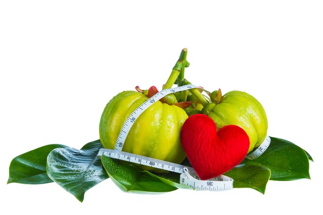 Garcinia cambogia with measuring tape, isolated on white backgro