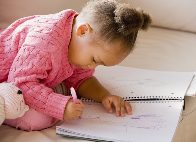 African girl drawing in notebook