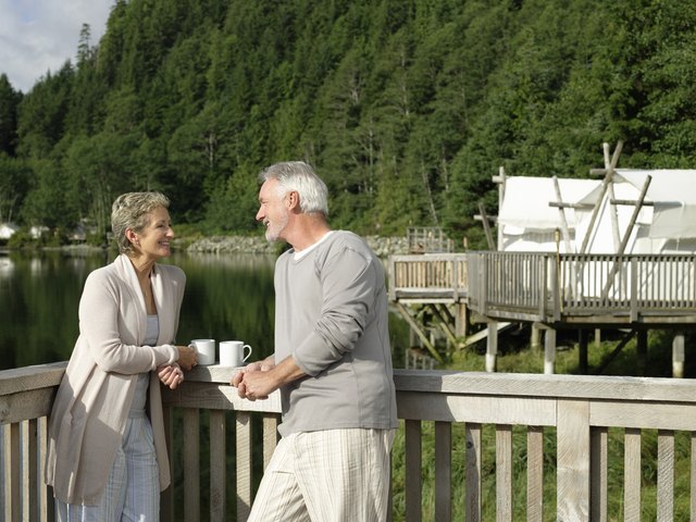 Mature couple relaxing on deck outside tent.
