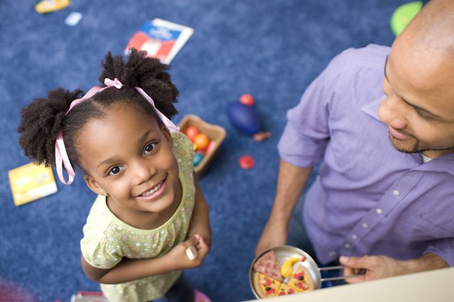 Portrait of girl with father in playroom
