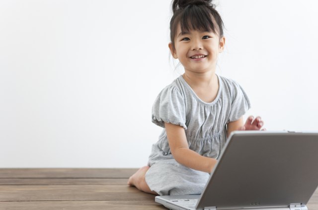 Portrait of girl using laptop, white background, copy space