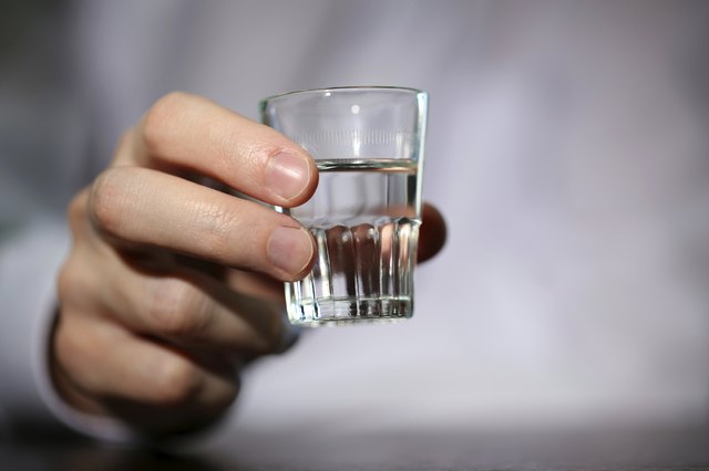 Man hand with glass of vodka , close up