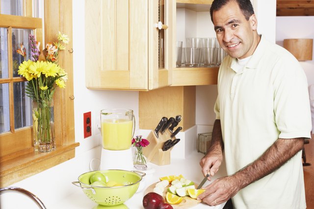Man chopping fruit in the kitchen
