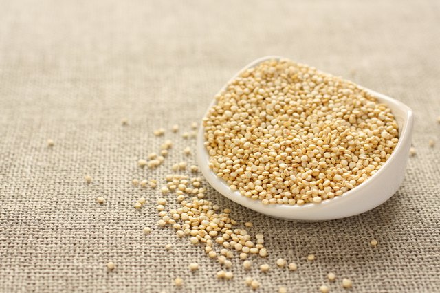 Quinoa grain in white ceramic bowl on sackcloth background