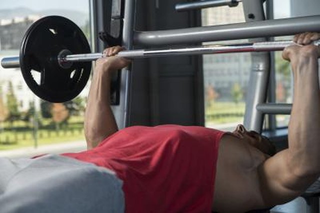 Young Men In Gym Exercising On The Bench Press