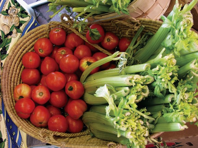 A basket of tomatoes and celery stalks