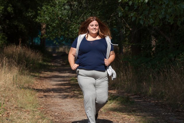 Overweight woman running outdoors