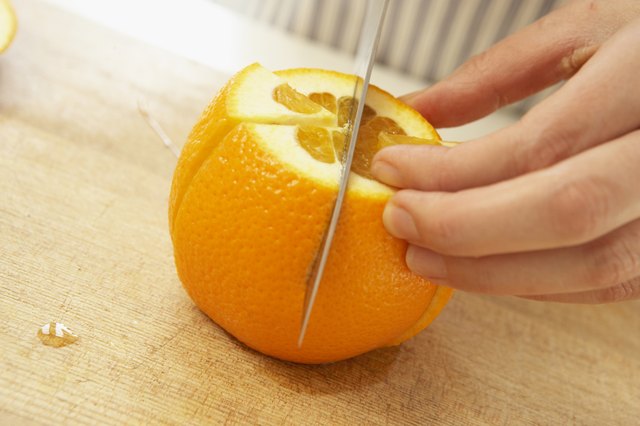 Woman cutting orange, close up
