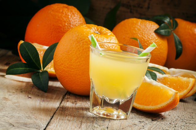Orange juice in a glass with striped straws