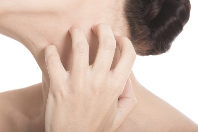 Young beautiful topless woman is scratching her neck.