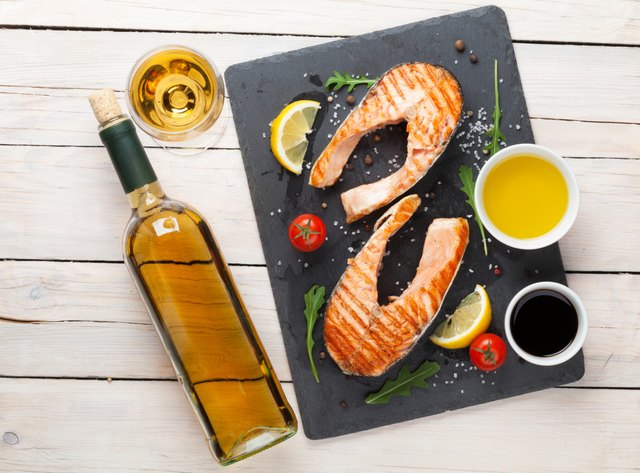 Grilled salmon and white wine on wooden table