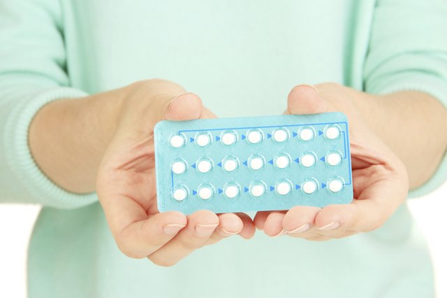 Hormonal pills in female hands isolated on white