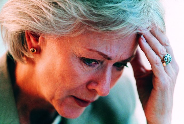 Worried businesswoman resting head in hand