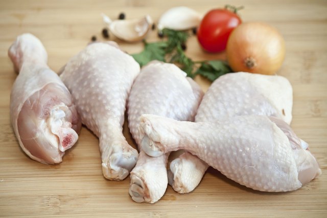 Raw chicken legs with vegetables and spices