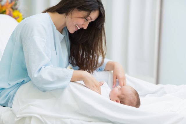 Joyful mother standing on top of a new born baby