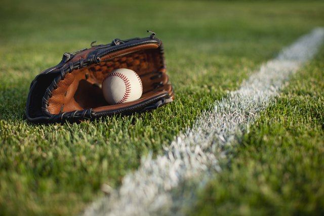 Baseball mitt and ball in grass with selective focus