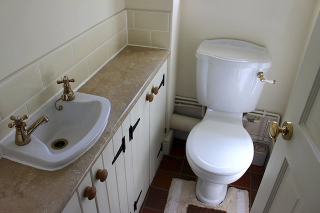 Image of country style cloakroom toilet, basin and storage cupboards