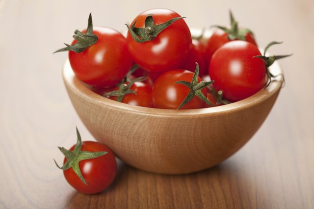 ripe tomatoes in wooden bowl
