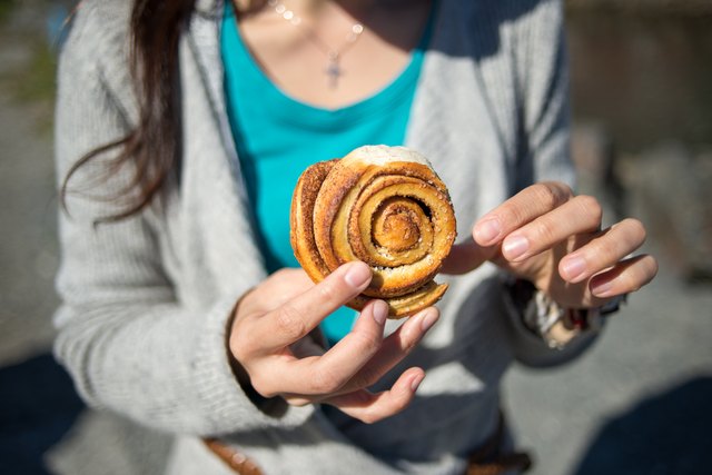 A lady holding a cinnamon bun